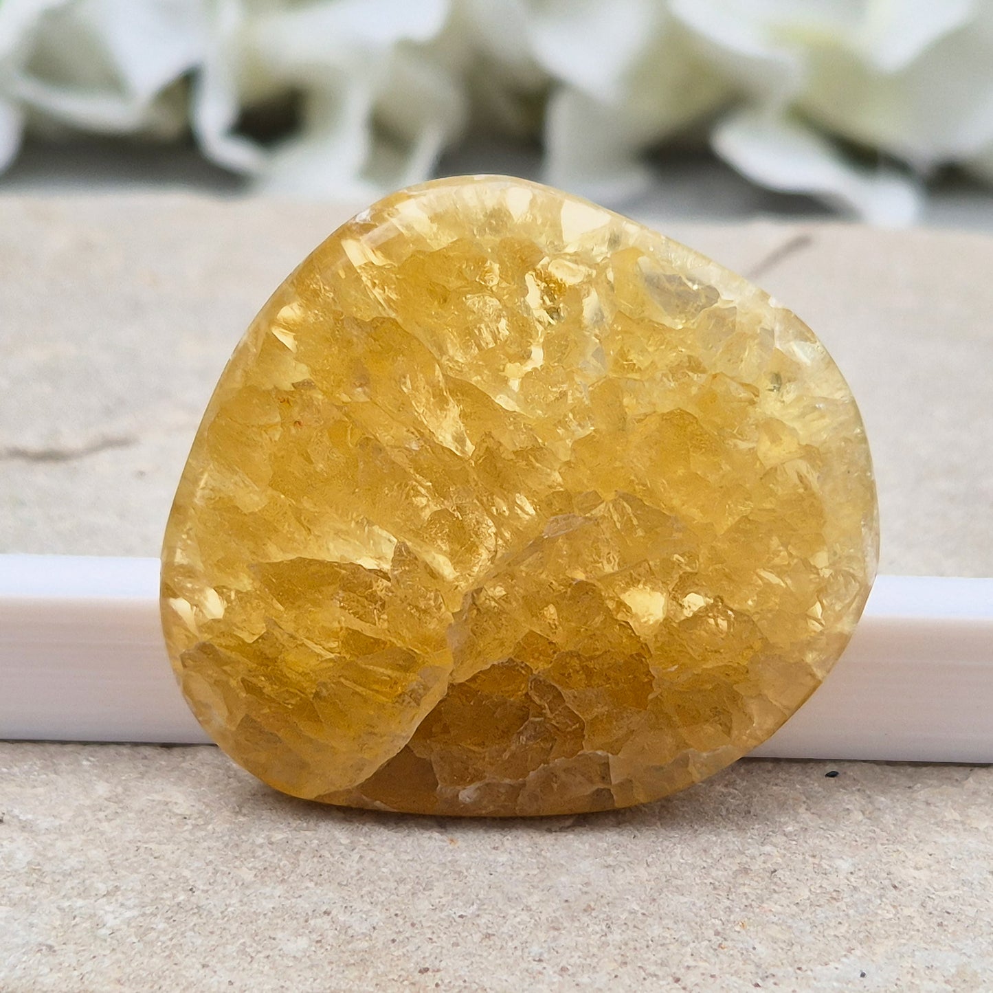 Honey Calcite Crystal Palm Stone, sometimes refered to as Golden Calcite or Amber Calcite. A smooth, pocket-sized palm stone in warm honey-gold tones, ranging from pale lemon-yellow to deep amber.