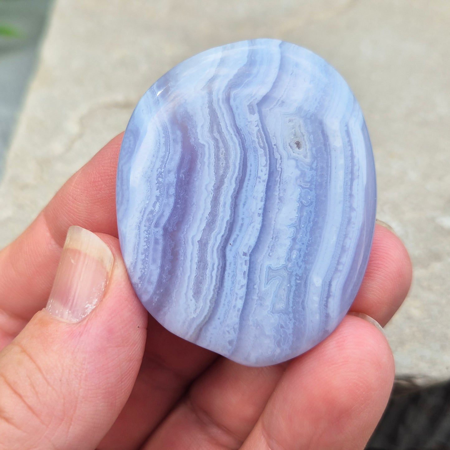Polished Blue Lace Agate crystal palm stone with wonderful banding. A calming crystal, ideal for relaxation, clear communication and gentle healing.