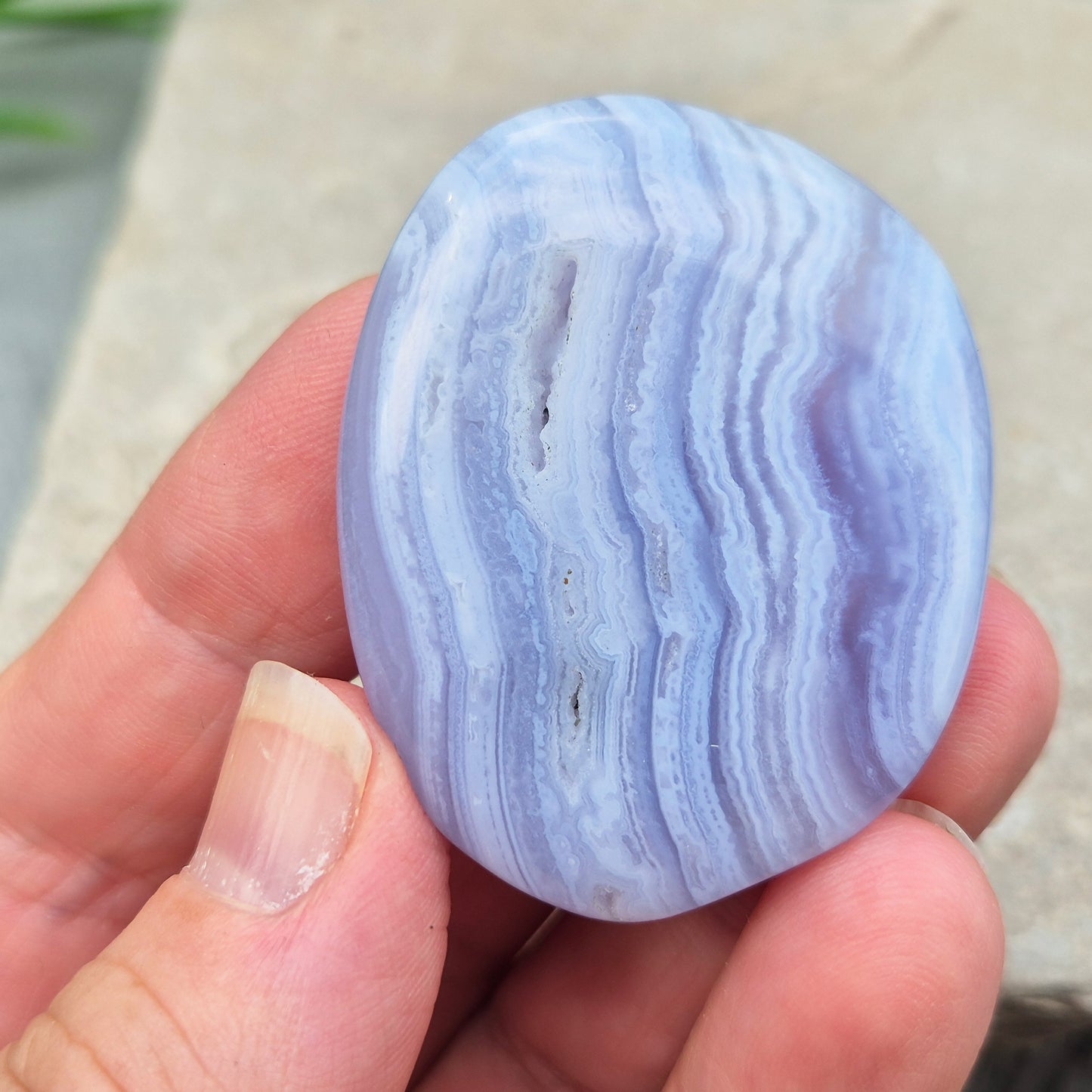 Polished Blue Lace Agate crystal palm stone with wonderful banding. A calming crystal, ideal for relaxation, clear communication and gentle healing.