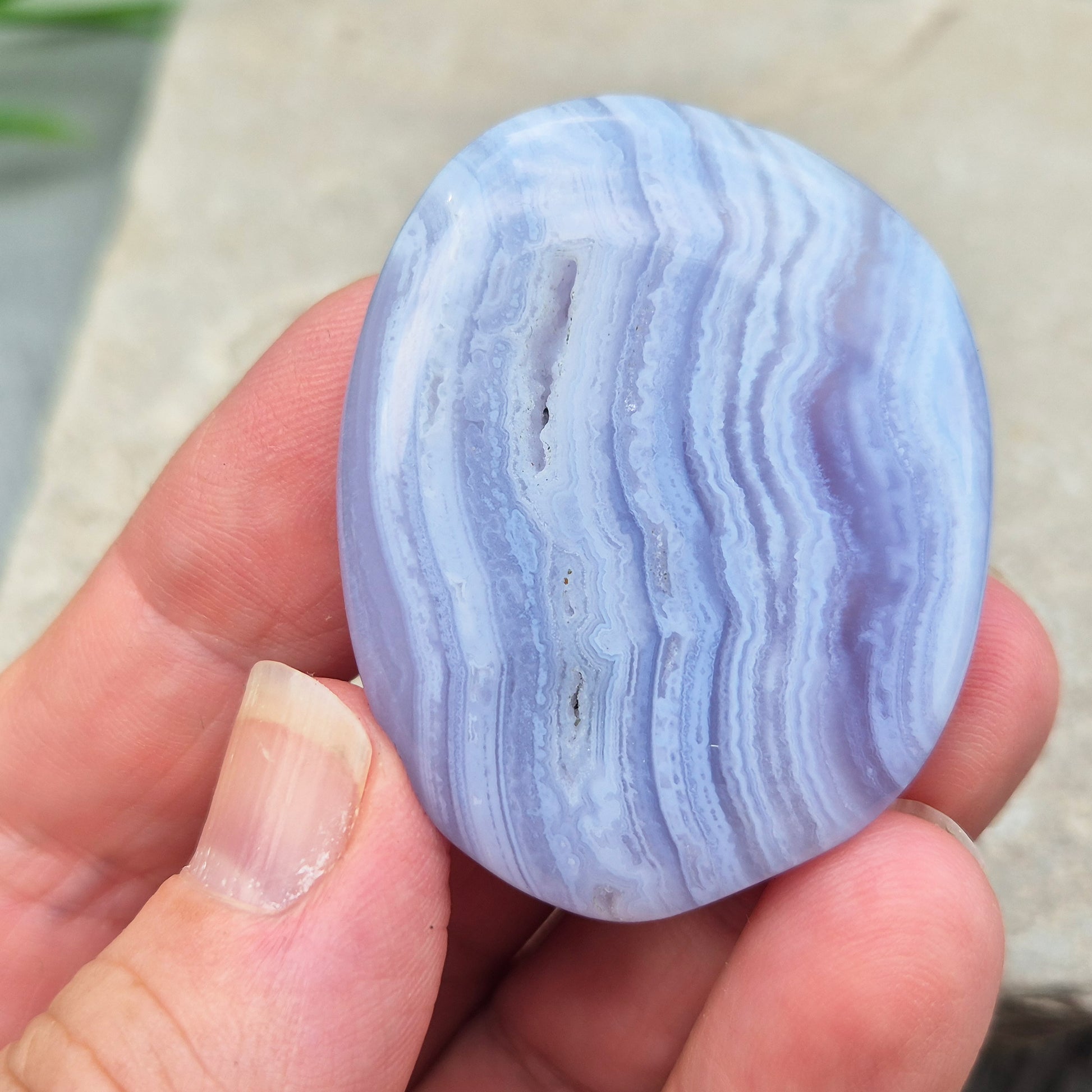Polished Blue Lace Agate crystal palm stone with wonderful banding. A calming crystal, ideal for relaxation, clear communication and gentle healing.