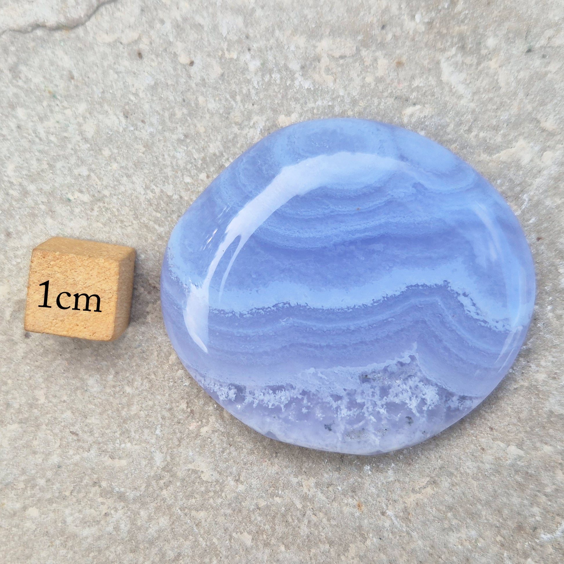 Polished Blue Lace Agate palm stone from Namibia. Often associated with calm communication and easing emotional tension, with soft blue banding throughout.