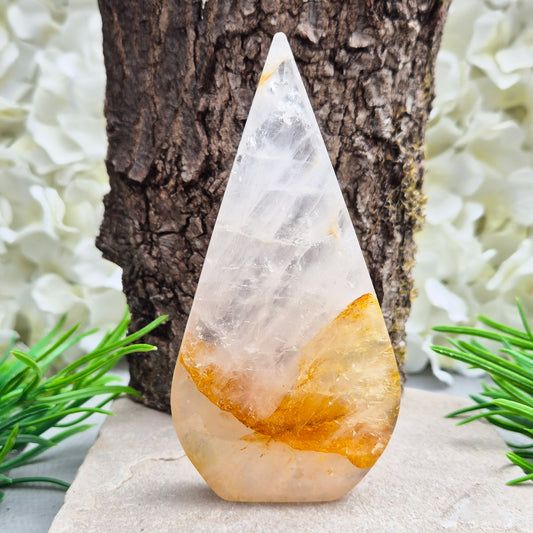 This Golden Healer Quartz teardrop is polished from Brazilian quartz, threaded through with golden inclusions of iron oxide inclusions (also known in the trade as yellow hematoid quartz). The smooth teardrop shape tapers to a clean point, standing upright on its own, with the golden banding visible right through the stone.