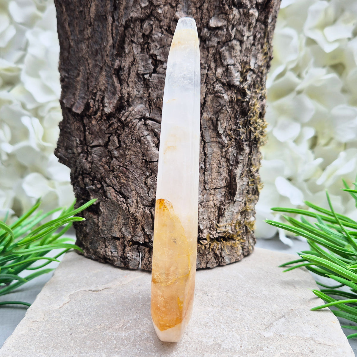 This Golden Healer Quartz teardrop is polished from Brazilian quartz, threaded through with golden inclusions of iron oxide inclusions (also known in the trade as yellow hematoid quartz). The smooth teardrop shape tapers to a clean point, standing upright on its own, with the golden banding visible right through the stone.