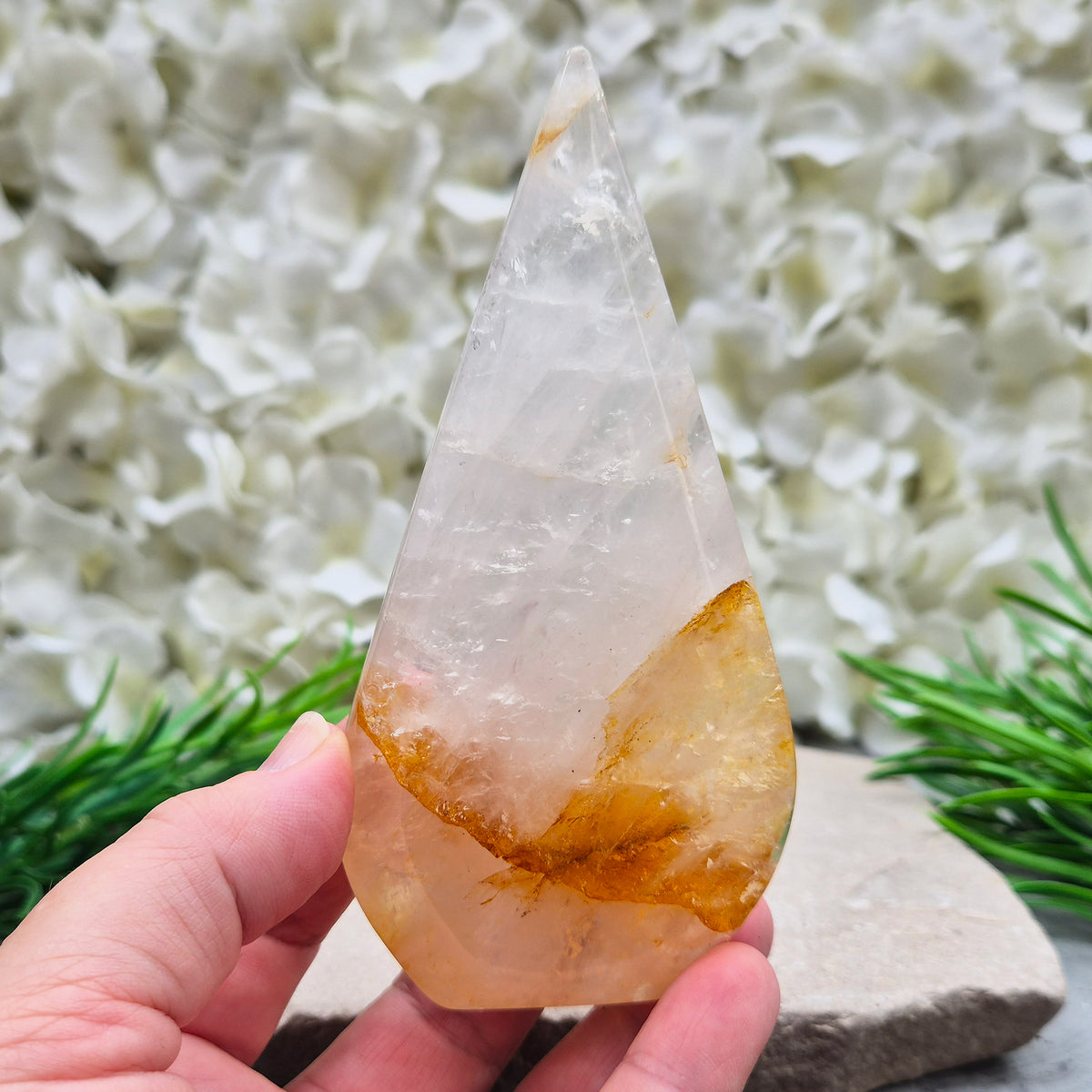 This Golden Healer Quartz teardrop is polished from Brazilian quartz, threaded through with golden inclusions of iron oxide inclusions (also known in the trade as yellow hematoid quartz). The smooth teardrop shape tapers to a clean point, standing upright on its own, with the golden banding visible right through the stone.