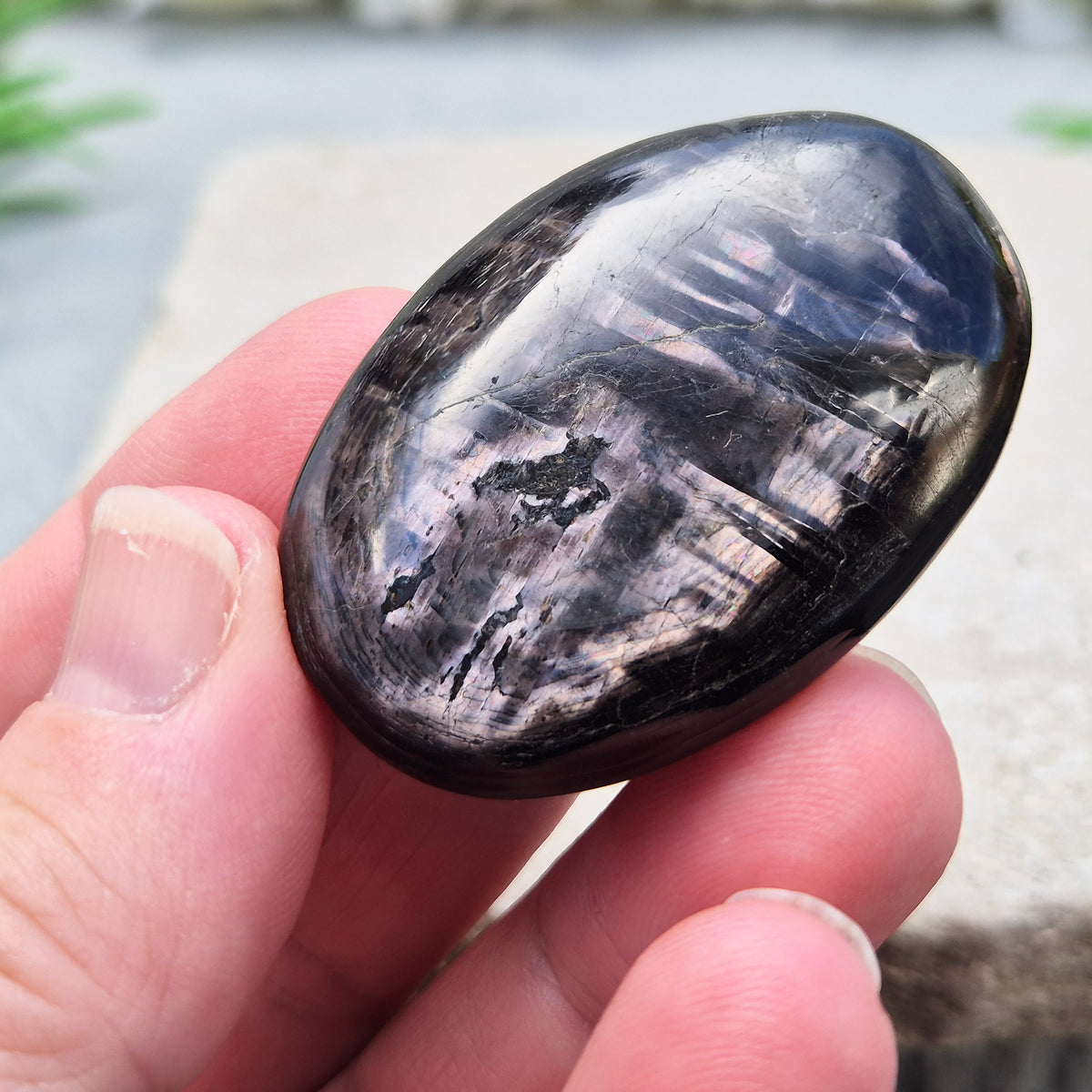Violet Hypersthene palm stone with a smooth, comforting feel. A grounding crystal often chosen for inner strength, calm focus, and quiet self-reflection.