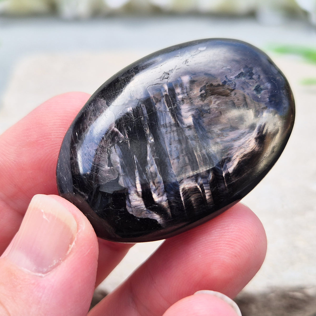 Violet Hypersthene palm stone with a smooth, comforting feel. A grounding crystal often chosen for inner strength, calm focus, and quiet self-reflection.