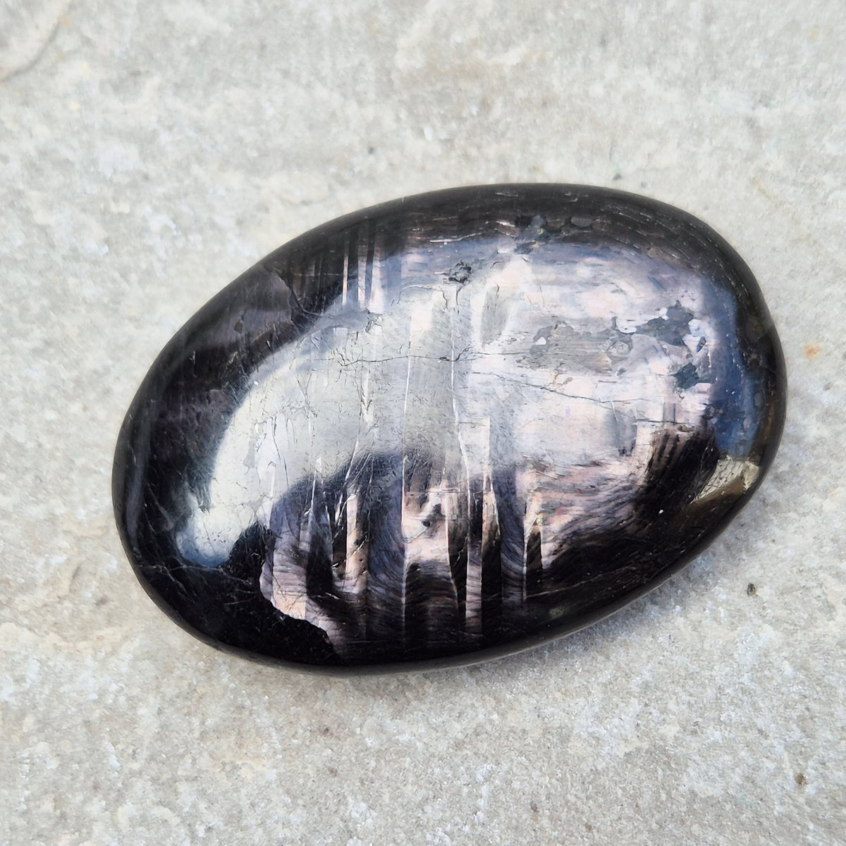 Violet Hypersthene palm stone with a smooth, comforting feel. A grounding crystal often chosen for inner strength, calm focus, and quiet self-reflection.
