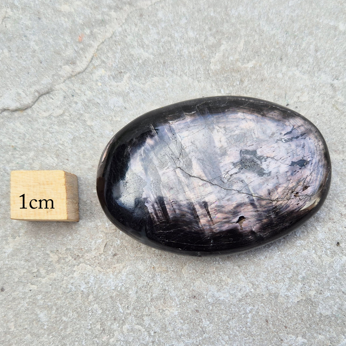 Violet Hypersthene palm stone with a smooth, comforting feel. A grounding crystal often chosen for inner strength, calm focus, and quiet self-reflection.