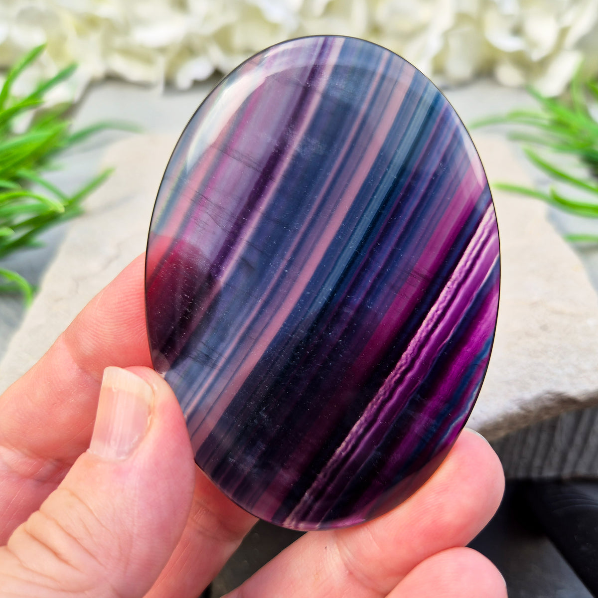 Fluorite palm stone for focus and balance. Polished banded crystal to calm the mind, support clear thinking and ease overwhelm.