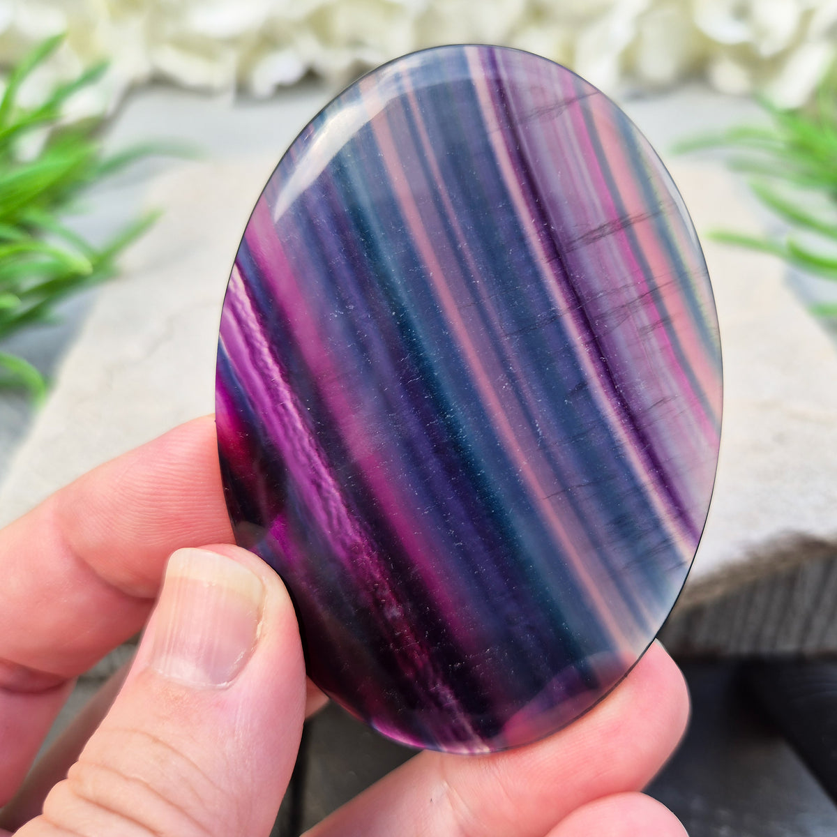 Fluorite palm stone for focus and balance. Polished banded crystal to calm the mind, support clear thinking and ease overwhelm.