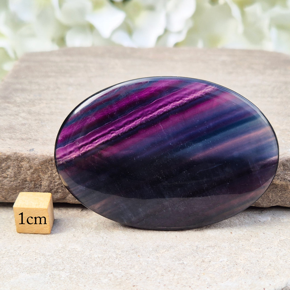 Fluorite palm stone for focus and balance. Polished banded crystal to calm the mind, support clear thinking and ease overwhelm.