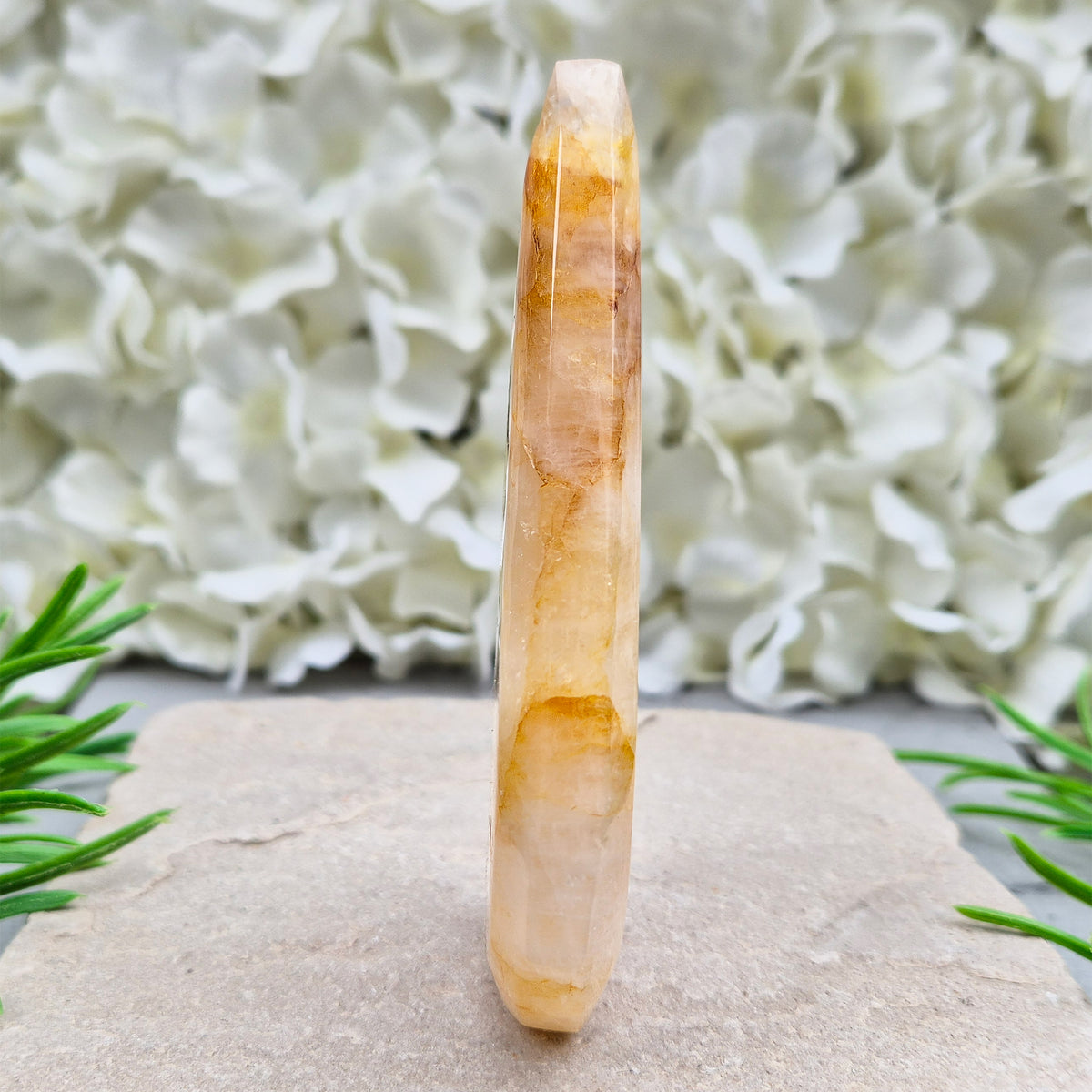 This Golden Healer Quartz teardrop is polished from Brazilian quartz, threaded through with golden inclusions of iron oxide inclusions (also known in the trade as yellow hematoid quartz). The smooth teardrop shape tapers to a clean point, standing upright on its own, with the golden banding visible right through the stone.