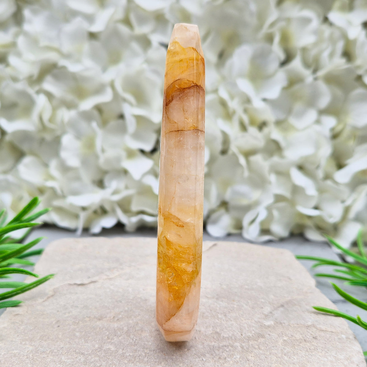 This Golden Healer Quartz teardrop is polished from Brazilian quartz, threaded through with golden inclusions of iron oxide inclusions (also known in the trade as yellow hematoid quartz). The smooth teardrop shape tapers to a clean point, standing upright on its own, with the golden banding visible right through the stone.