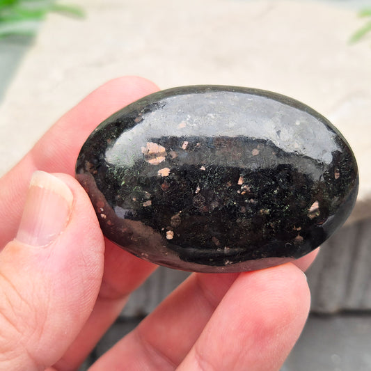 Genuine Nuummite palm stone from Greenland, known as the Sorcerer's Stone. Often associated with protection, intuition, courage and clearing blockages.