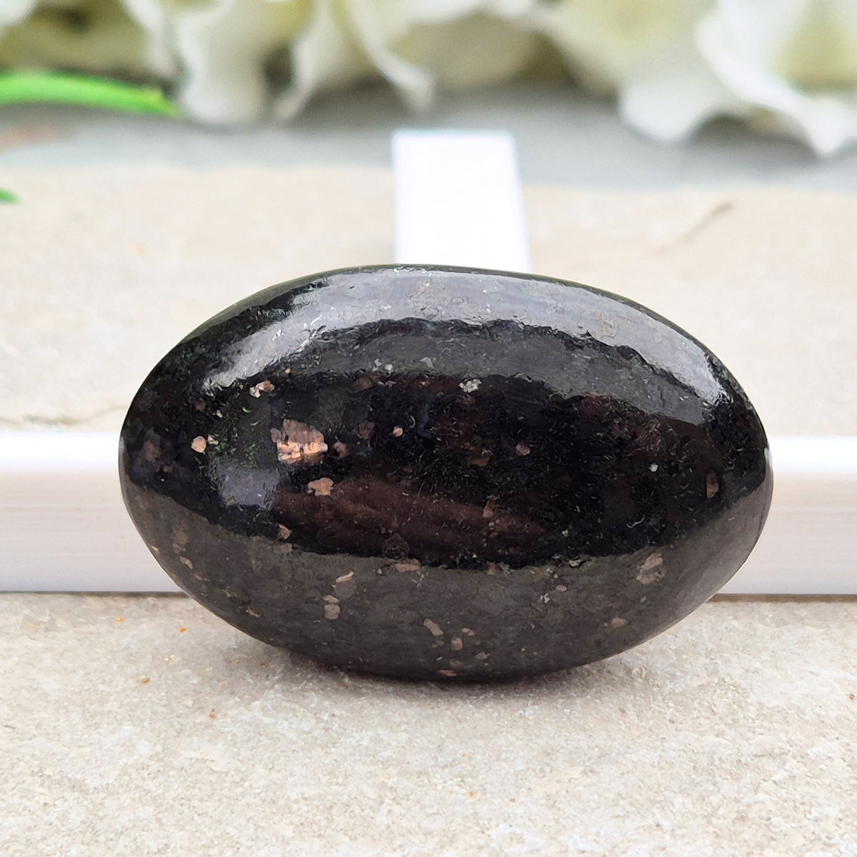 Genuine Nuummite palm stone from Greenland, known as the Sorcerer's Stone. Often associated with protection, intuition, courage and clearing blockages.