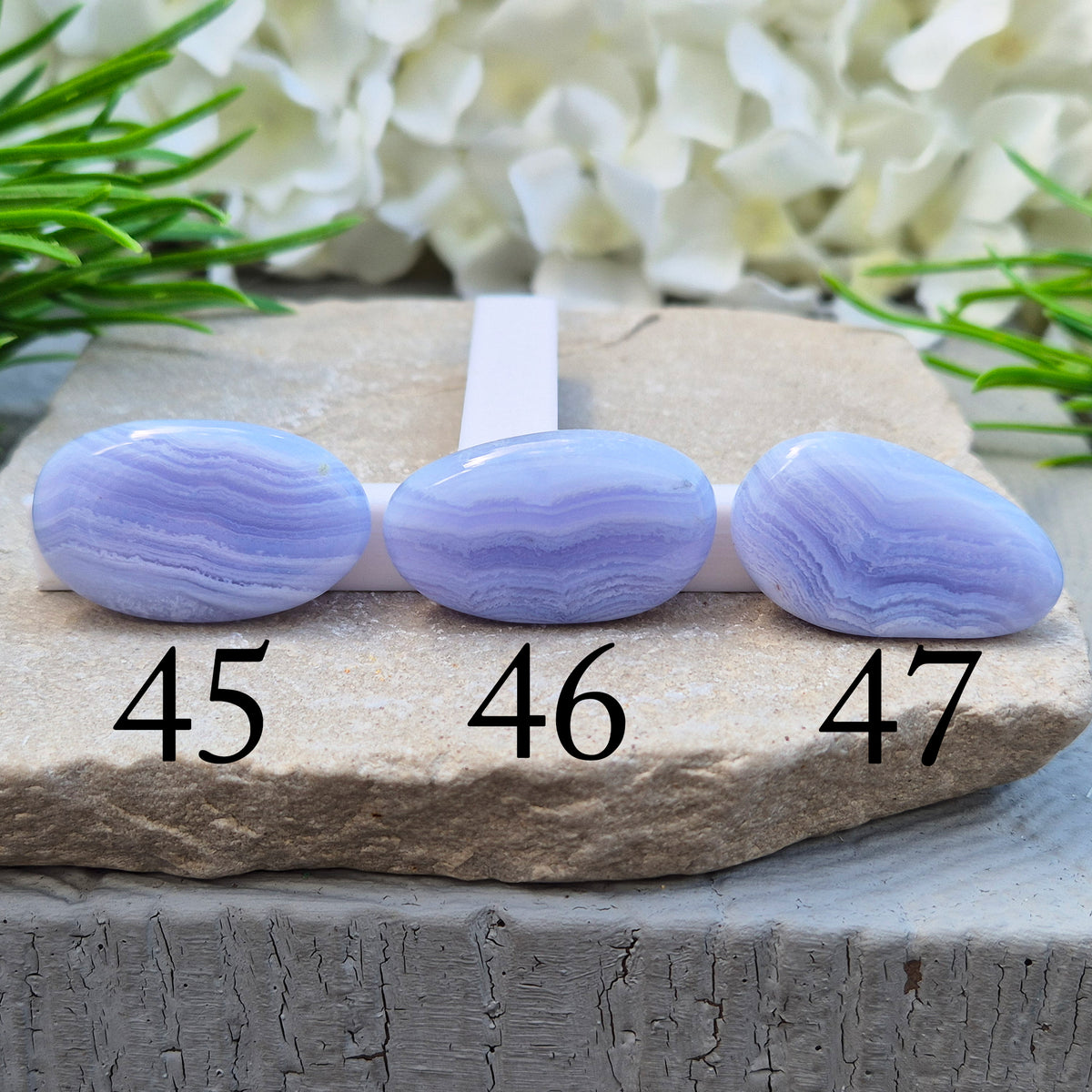 Polished Blue Lace Agate palm stone from Namibia. Often associated with calm communication and easing emotional tension, with soft blue banding throughout.