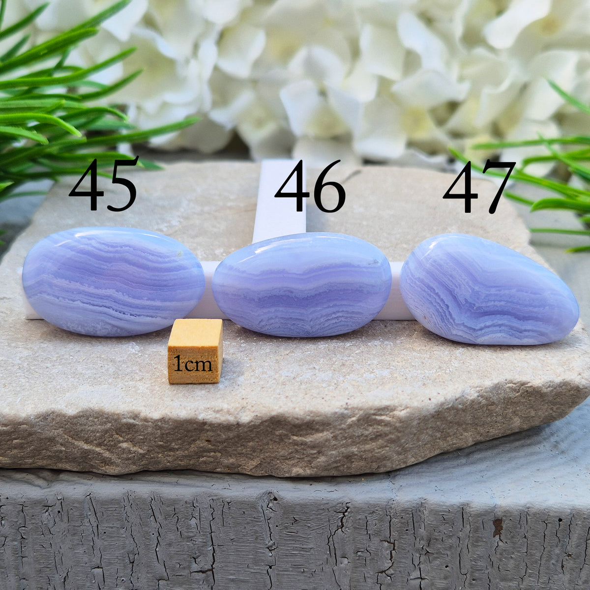 Polished Blue Lace Agate palm stone from Namibia. Often associated with calm communication and easing emotional tension, with soft blue banding throughout.
