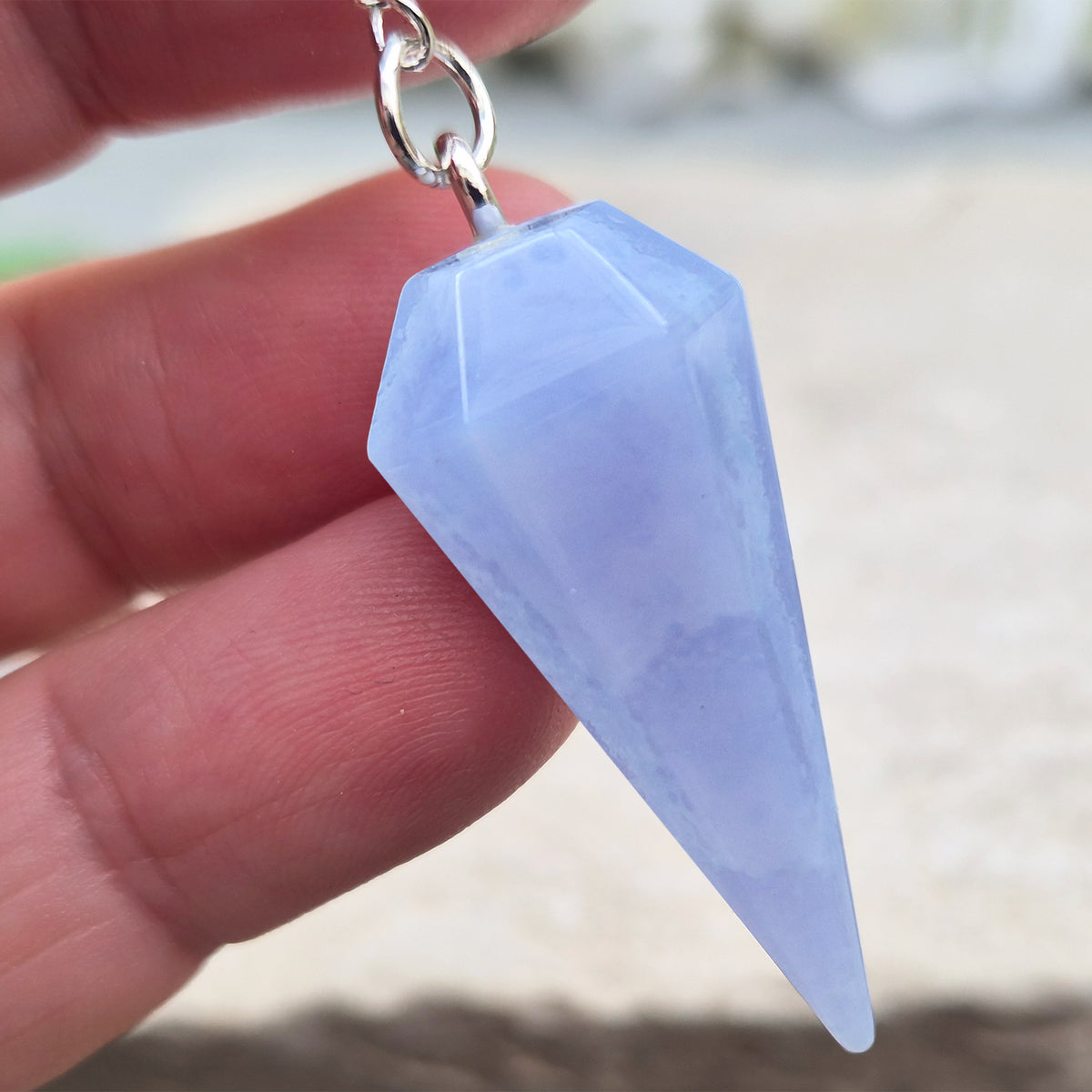 Blue Lace Agate crystal pendulum, known for its calming energy. Ideal for dowsing, spiritual guidance, and bringing a steady, peaceful feel.