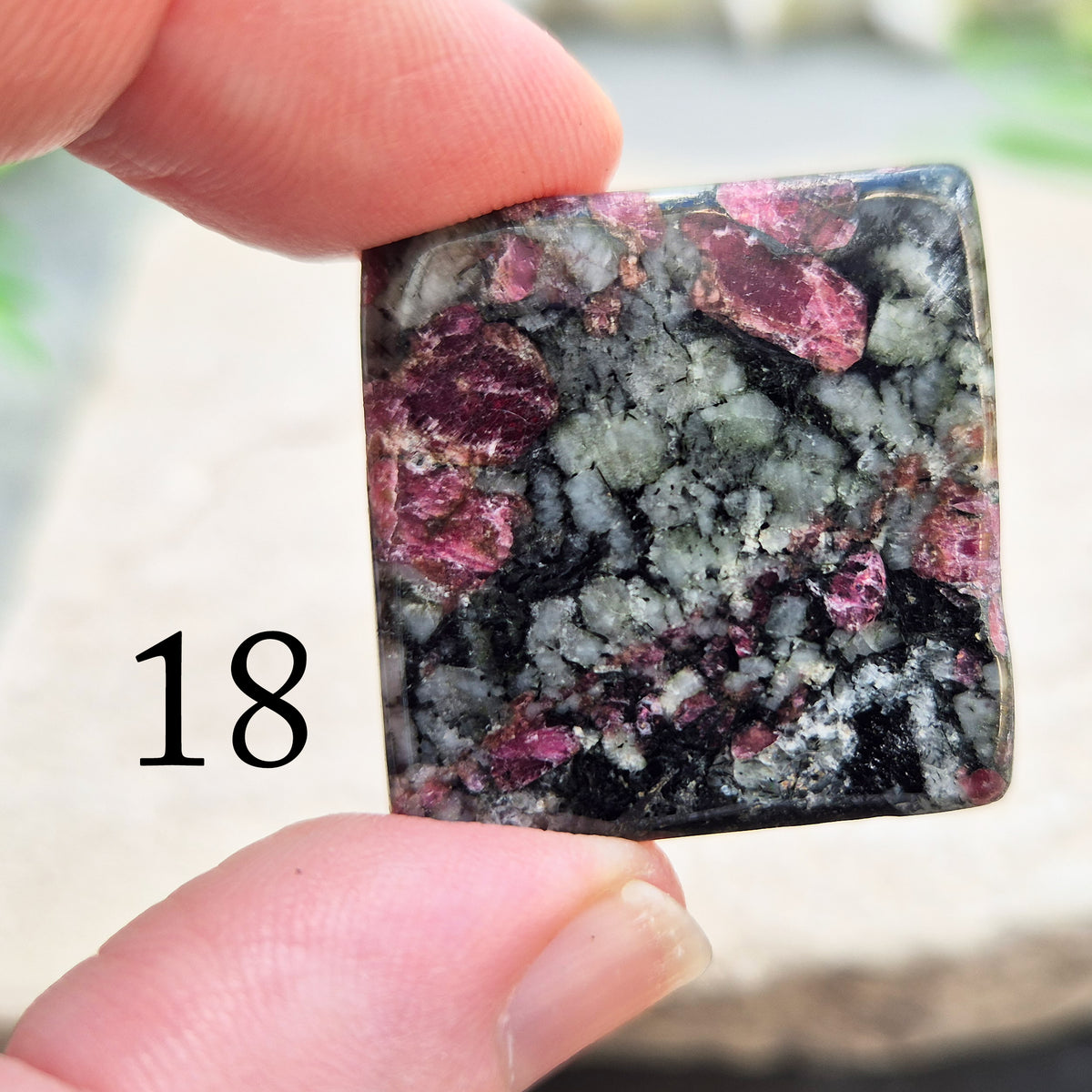 Hand-picked polished eudialyte slice with raspberry-pink and natural black and grey patterning. Often reached for heart-centred meditation.