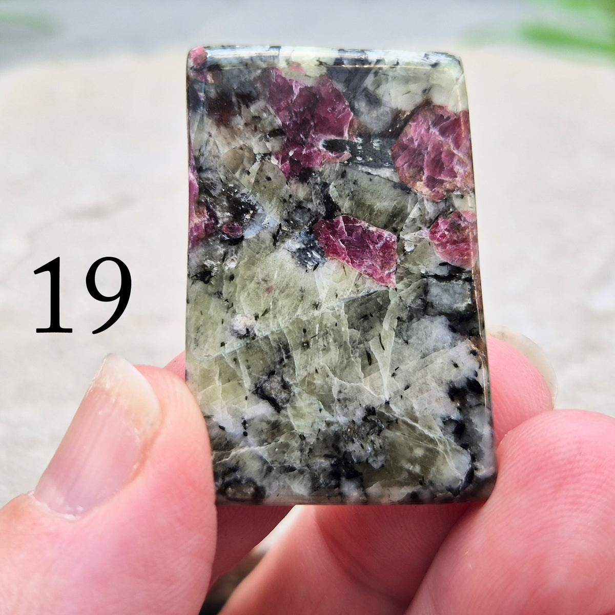 Hand-picked polished eudialyte slice with raspberry-pink and natural black and grey patterning. Often reached for heart-centred meditation.