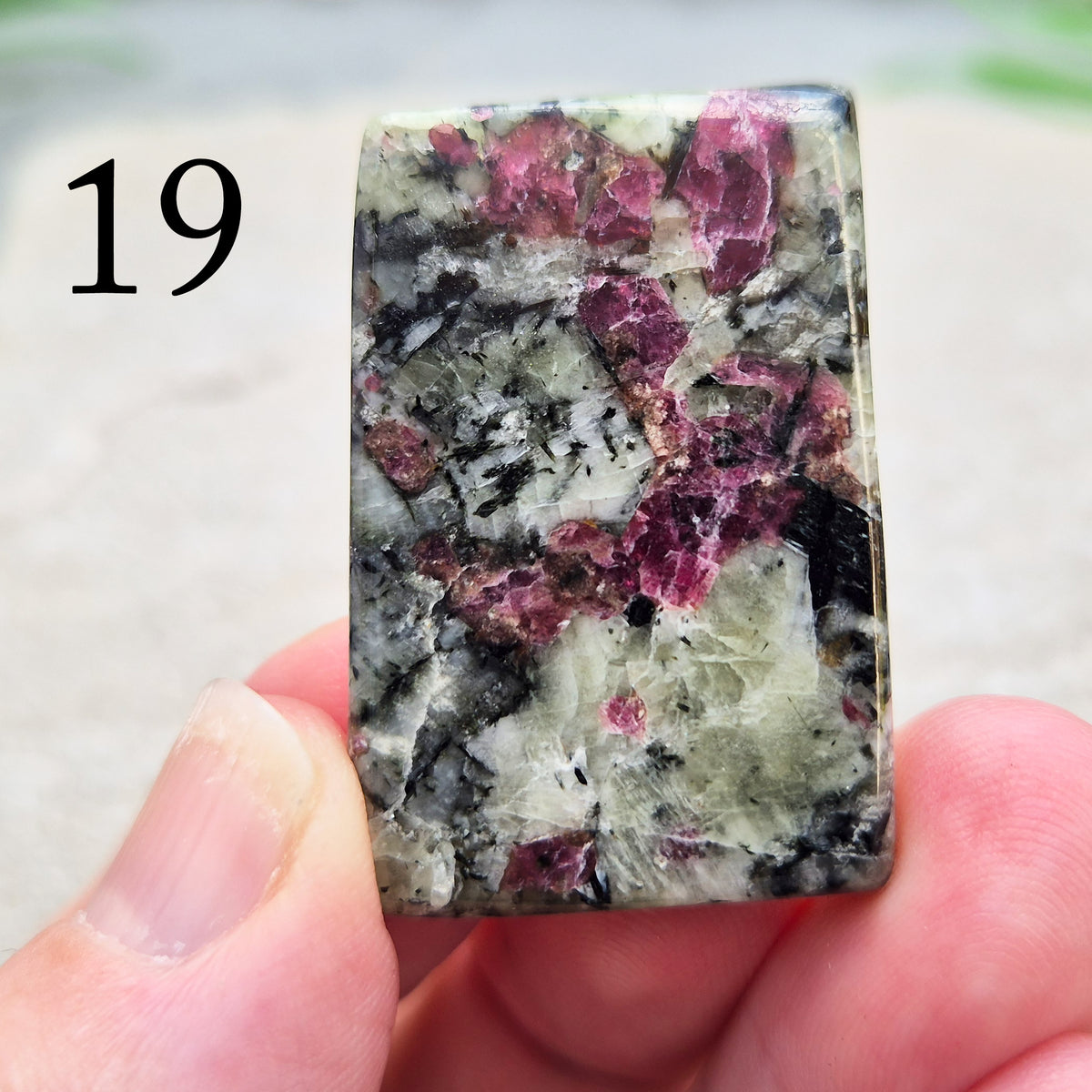 Hand-picked polished eudialyte slice with raspberry-pink and natural black and grey patterning. Often reached for heart-centred meditation.