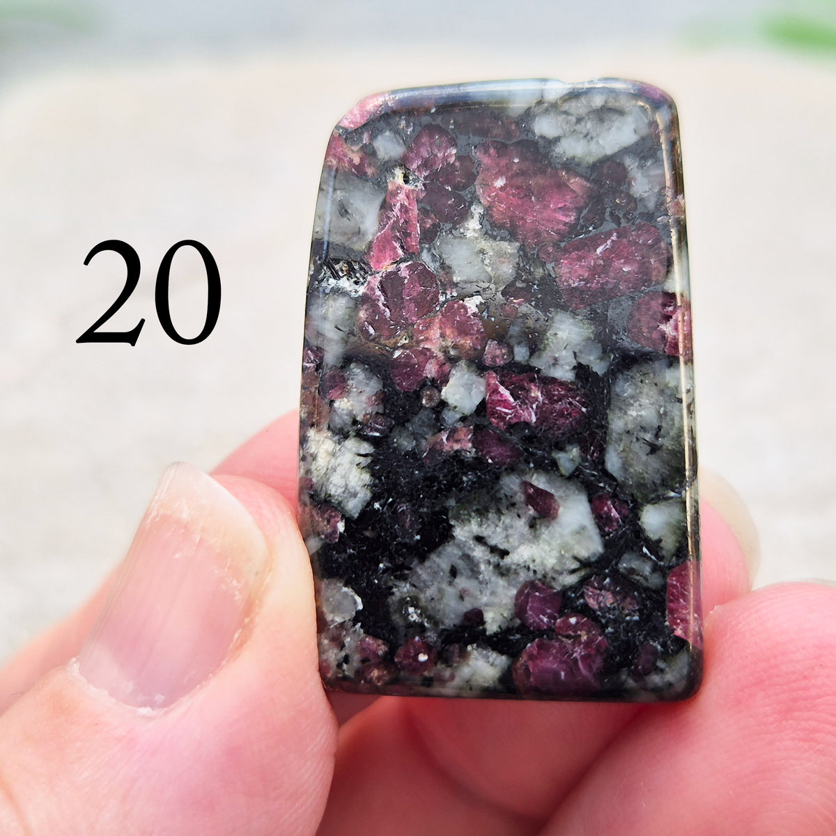 Hand-picked polished eudialyte slice with raspberry-pink and natural black and grey patterning. Often reached for heart-centred meditation.