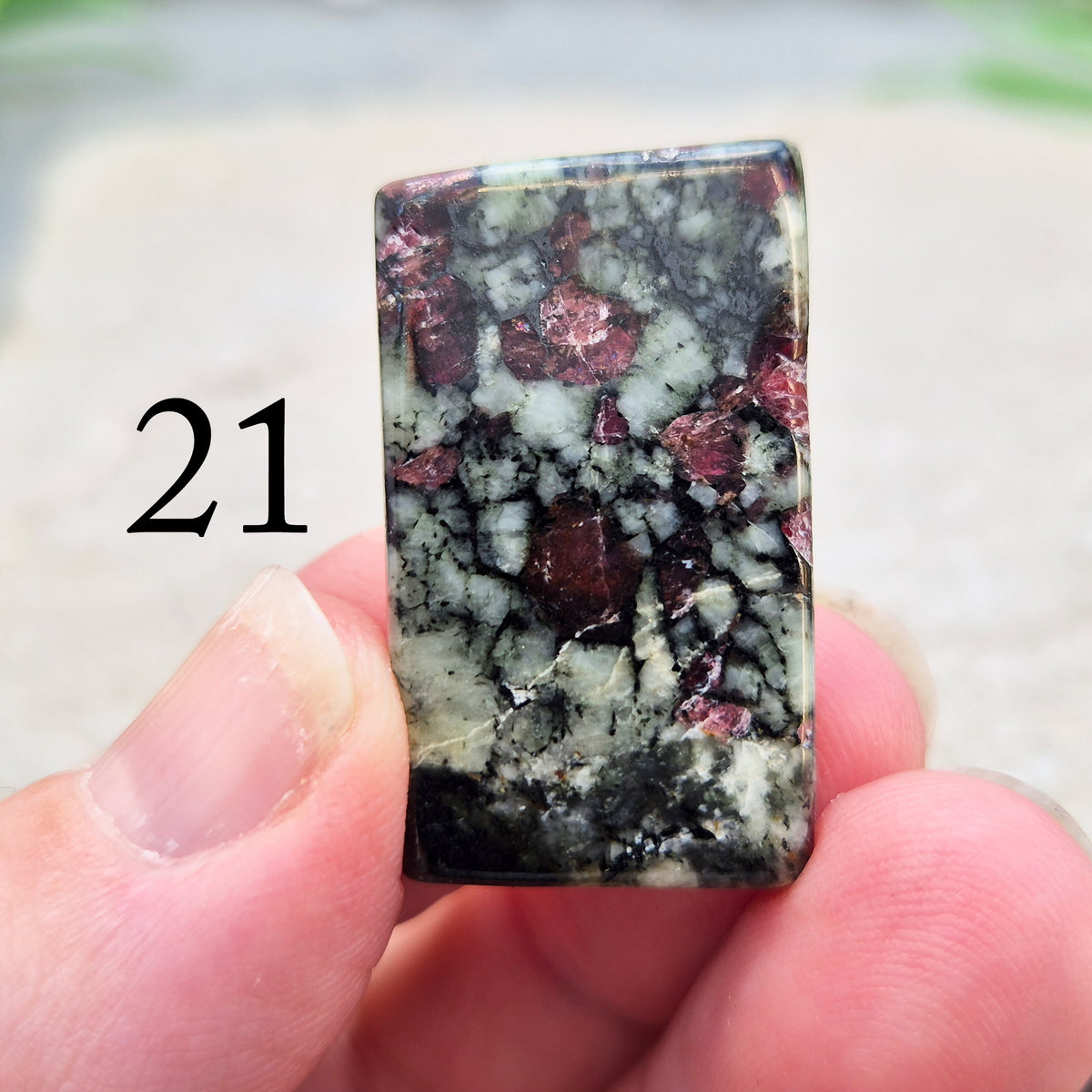 Hand-picked polished eudialyte slice with raspberry-pink and natural black and grey patterning. Often reached for heart-centred meditation.