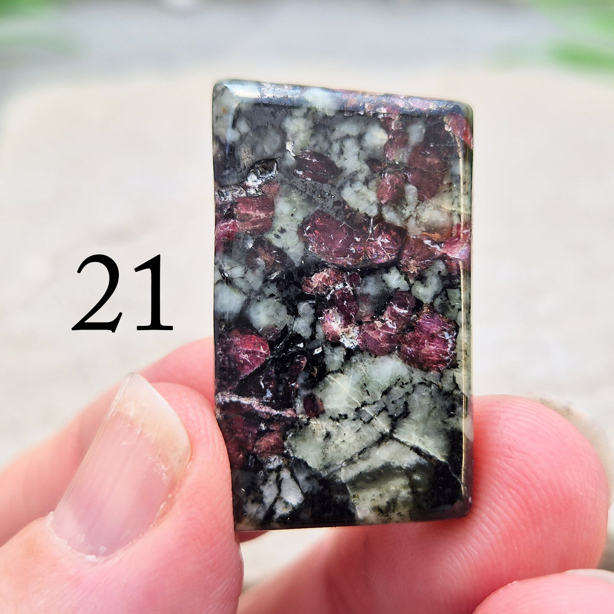 Hand-picked polished eudialyte slice with raspberry-pink and natural black and grey patterning. Often reached for heart-centred meditation.