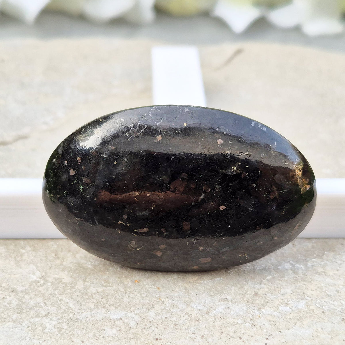 Genuine Nuummite palm stone from Greenland, known as the Sorcerer's Stone. Often associated with protection, intuition, courage and clearing blockages.
