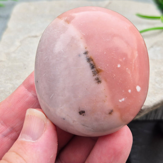Pink Opal palm stone from Peru with soft pink to salmon tones and a glossy polish. A gentle heart chakra crystal for grief, heartbreak and emotional healing.