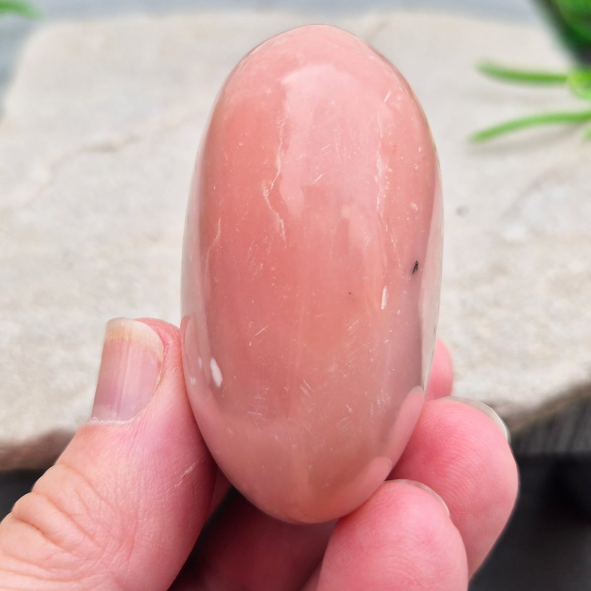 Pink Opal palm stone from Peru with soft pink to salmon tones and a glossy polish. A gentle heart chakra crystal for grief, heartbreak and emotional healing.