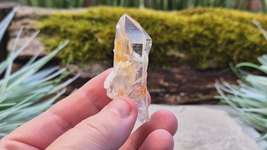 This rare Blade of Light Quartz is a striking Lemurian Quartz from the mountains of Colombia. Known for its exceptional clarity and natural brilliance, this piece features a point that has a few smaller crystals growing out of/into it. 