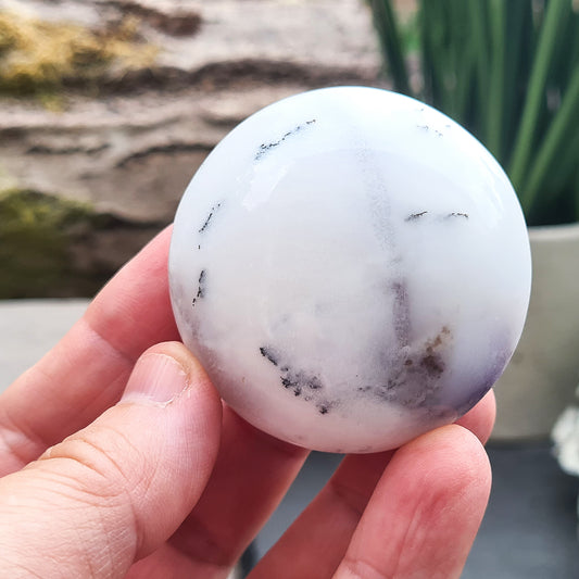 Merlinite Galet from Madagascar. Fabulous, off white, grey and Lavender colouring. These Merlinite Galets are made up of White Opal and dendritic (fern like) inclusions of a black mineral called Psilomelane ( a black manganese oxide). Its a fabulous crystal. Circular in shape.